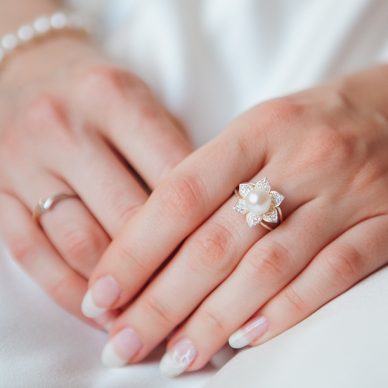 bride Hand with Diamond ring and pearl bracelet on white dress