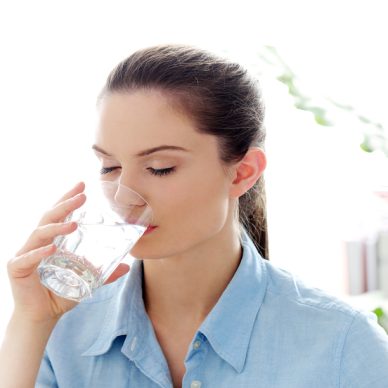 Morning. Attractive woman with glass of water