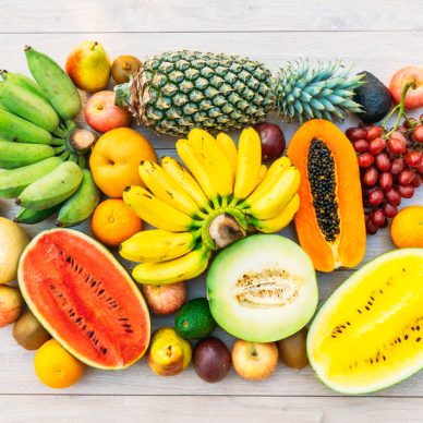 Mixed fruits with apple banana orange and other on wooden background - Healthy food style