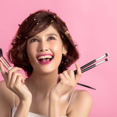 Short hair asian young beautiful woman applying cosmetic powder brush