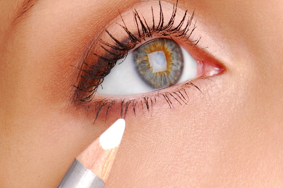 White Cosmetic pencil. Make-up tool. Womun eye is close-up.