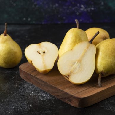 Wooden board of delicious yellow pears on black surface. High quality photo