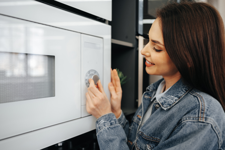 Close up photo of a woman checking new microwave oven in hypermarket