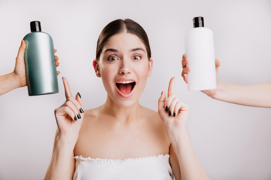 Closeup portrait of joyful girl posing without makeup on white background. Woman chose which shampoo is best to use