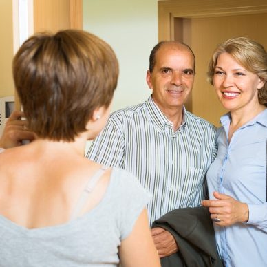 Smiling mature family couple visiting daughter at home