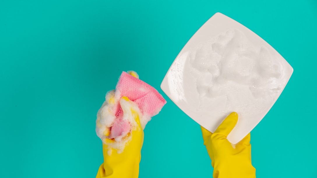 The concept of dishwasher wearing yellow gloves on a blue background.