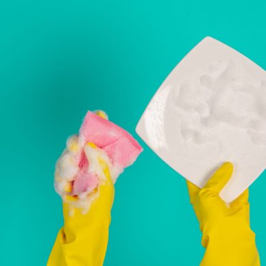 The concept of dishwasher wearing yellow gloves on a blue background.