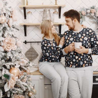 People in a Christman decorations. Man and woman in a identifical pajamas. Family in a kitchen.