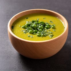 Green pea soup on black slate background