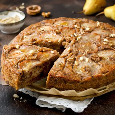 Pear pie with walnuts and chocolate chips on old stone background