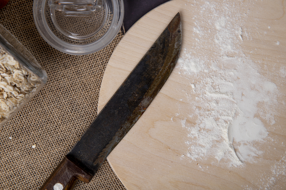 close-up view of white flour with knife on wooden cutting board on sackcloth surface