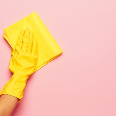 The woman's hand cleaning on a pink background. Cleaning or housekeeping concept background. Frame for text or advertising