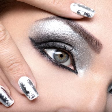 Beautiful girl with the silver  makeup of eyes and  metal nails. Fashion woman portrait. Closeup shot of female eye.