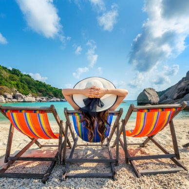 Woman with hat sitting on chairs beach in beautiful tropical beach. Woman relaxing on a tropical beach at Koh Nangyuan island.