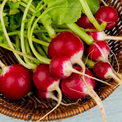 close-up view of radishes in basket on wooden background