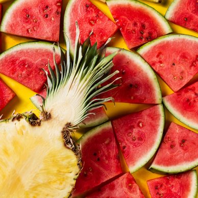 Summer concept. Conceptual. Tasty appetizing slice of pineapple with watermelon slices on yellow bright vibrant background with wooden letters Summer. Flat Lay.