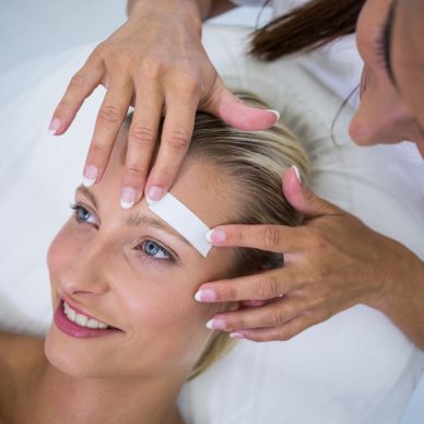 Woman getting her eyebrows shaped at beauty salon