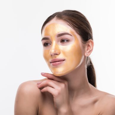 Woman Gold Mask, Beautiful Model with Golden Skin Cosmetic touch Face, Beauty Skincare and Treatment