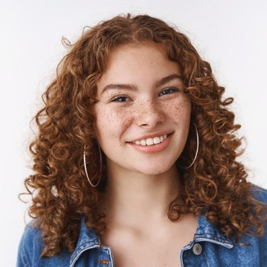 Close-up attractive confident smiling redhead curly-haired girl freckles acne prone skin unbothered pimples enjoy leading body-positive lifestyle, standing white background carefree.