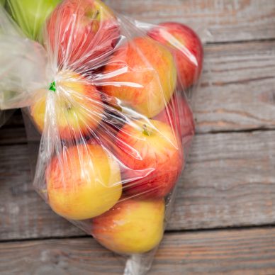 Apple fruit in plastic bag on wood table