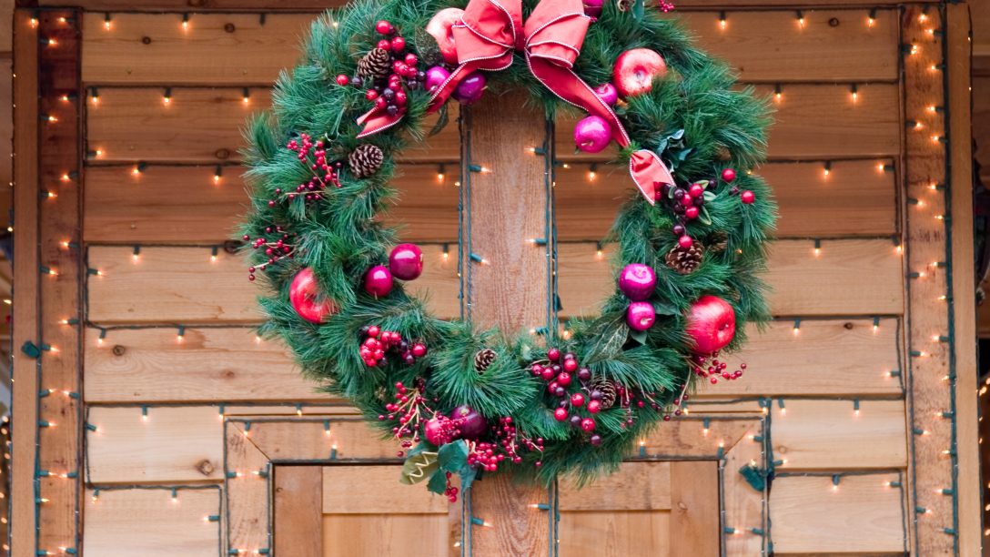 Christmas Wreath on natural wood doorway with strings of lights