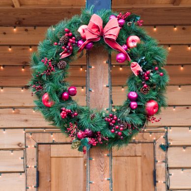 Christmas Wreath on natural wood doorway with strings of lights
