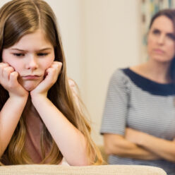 Daughter sitting upset with her mother in living room