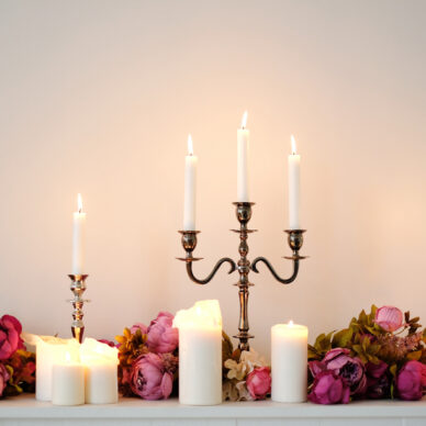 Burning candles on a white wall background