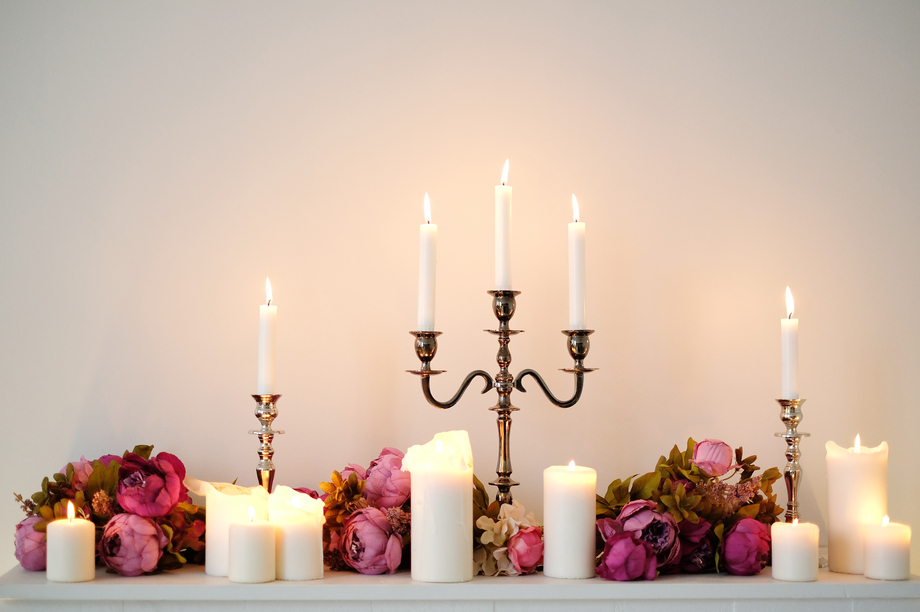 Burning candles on a white wall background