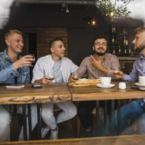 smiling-young-male-friends-enjoying-drinks-restaurant (1)