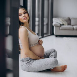 Pregnant woman having rest after exercising at home