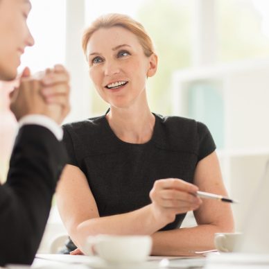 Multi-ethnic group of managers gathered together in boardroom and brainstorming on joint project, blurred background