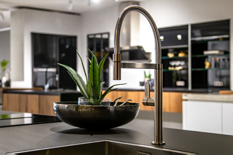 Steel faucet in a stylish modern kitchen. Minimalism in refurbished apartment.