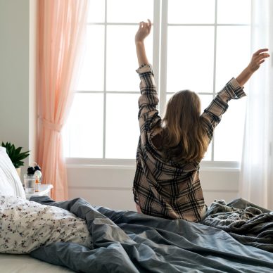 Rear view of woman stretching her arms in the morning