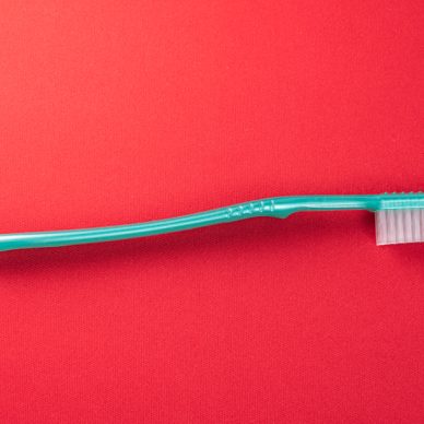 Green toothbrush on the red background