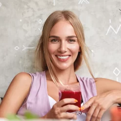 positive-beautiful-young-female-model-feels-relaxed-while-sits-comfortable-sofa-cafe-enjoys-fresh-strawberry-smoothie-recreate-summer-holidays-people-rest-lifestyle-concept