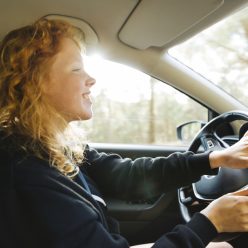 smiling-redhead-woman-driving-car (1)