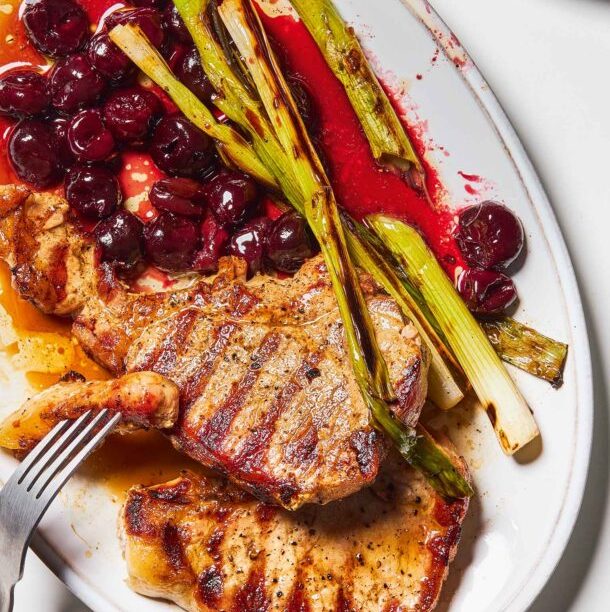 Χοιρινές μπριζόλες κόντρα με φρέσκο κρεμμυδάκι και καψαλισμένα κεράσια