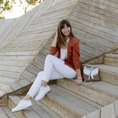 Happy   stylish female student posing in modern park , wesring white jeans, jacket and t-shirt.