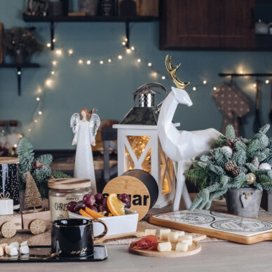 Black ceramic cup on wooden table with food on the background. New Year eve concept