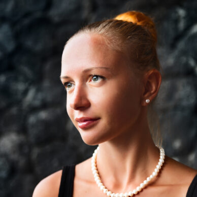 Portrait of red haired young woman with pearl necklace and earrings