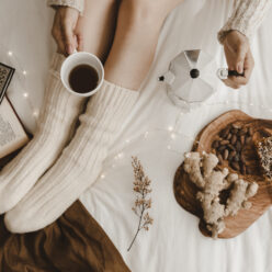 crop-lady-pouring-coffee-near-books-snacks (1)