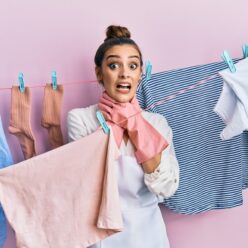 Beautiful brunette young woman washing clothes at clothesline shouting and suffocate because painful strangle. health problem. asphyxiate and suicide concept.