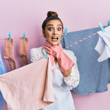 Beautiful brunette young woman washing clothes at clothesline shouting and suffocate because painful strangle. health problem. asphyxiate and suicide concept.