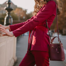 close up fashion details of stylish woman in purple suit walking in city street, spring summer autumn season fashion trend holding purse