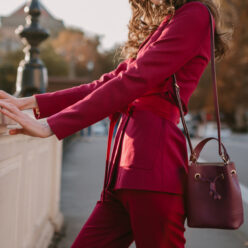 close up fashion details of stylish woman in purple suit walking in city street, spring summer autumn season fashion trend holding purse