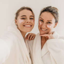 happy-caucasian-women-use-eye-patches-wear-bathrobes-look-camera-white-background-concept-preserving-youth (1)