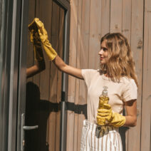 Young blonde housewife cleaning the house doors